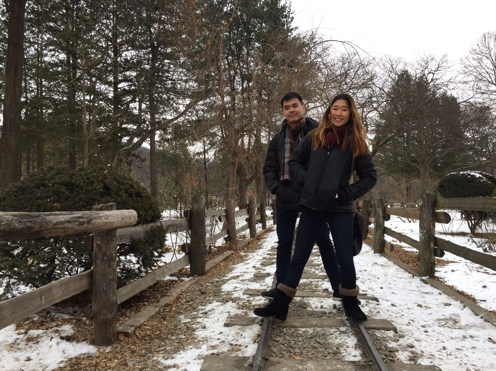 Nicholas and his wife standing on a snowy railway path on Nami Island