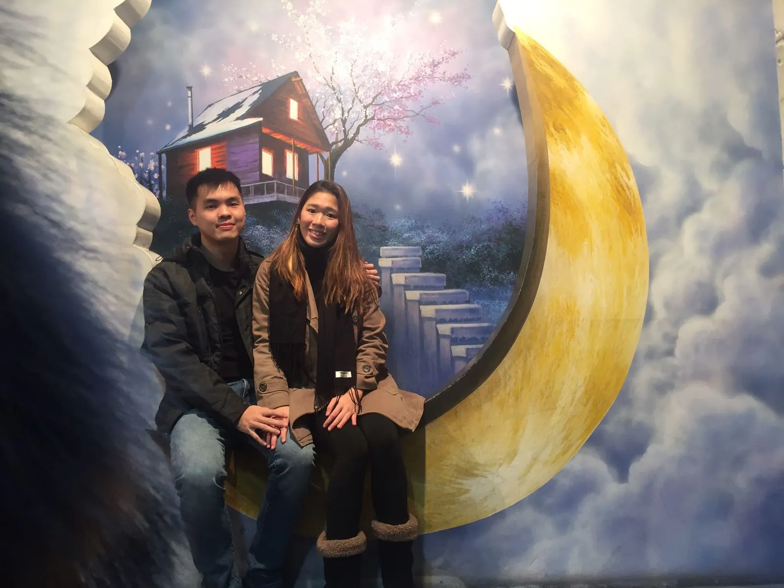 Nicholas and his wife posing with a moon illusion at Trickeye Museum