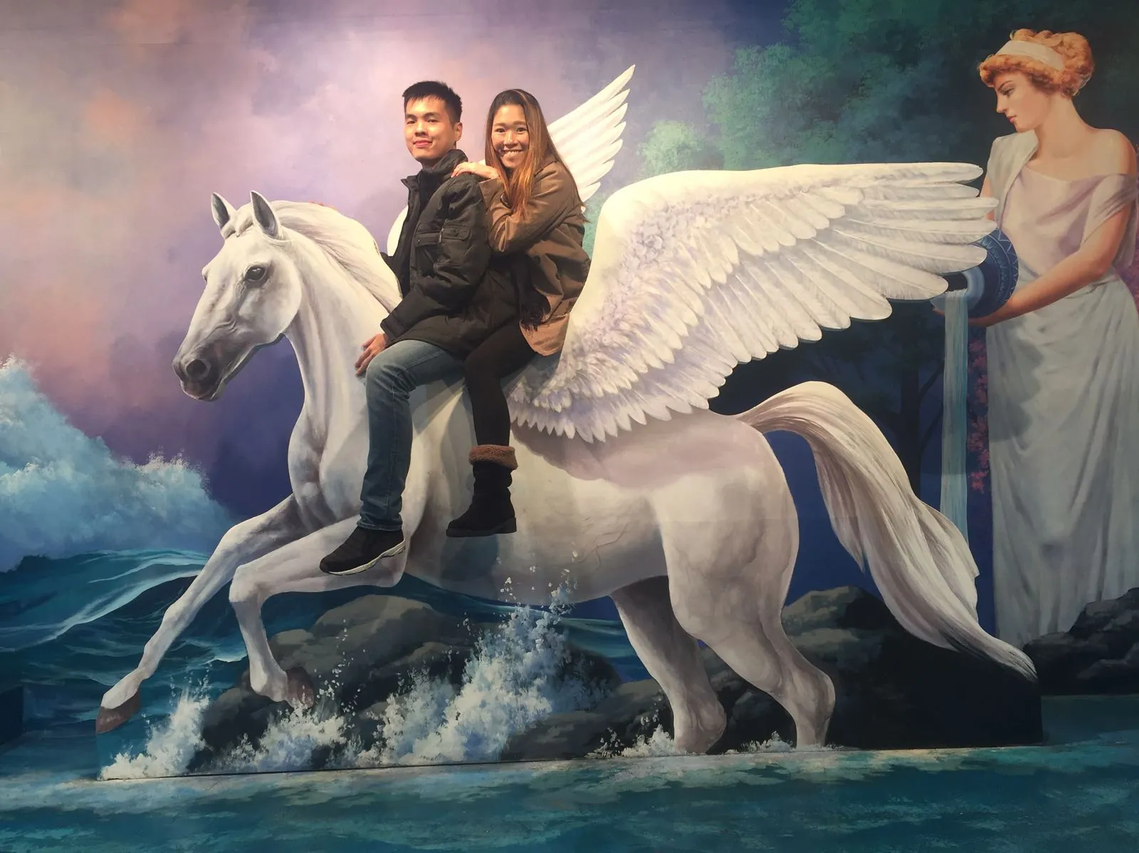 Nicholas and his wife posing with a winged horse illusion at Trickeye Museum