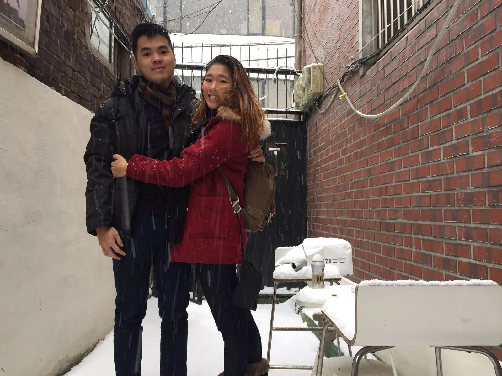 Nicholas and his wife standing in a snowy lane near their apartment in Yongsan-gu