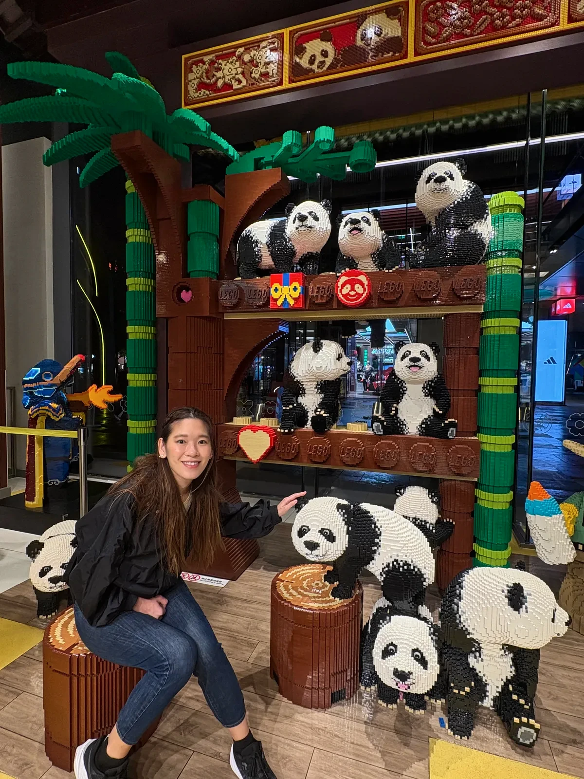 Woman sitting among brick-built panda sculptures in the LEGO store at Taikoo Li