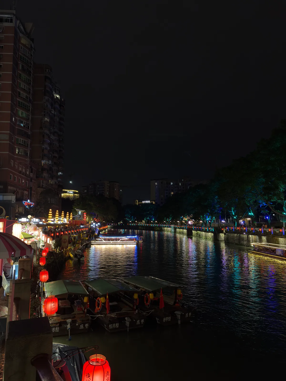 Lantern-lit boats on the river beside Dongmen Wharf at night