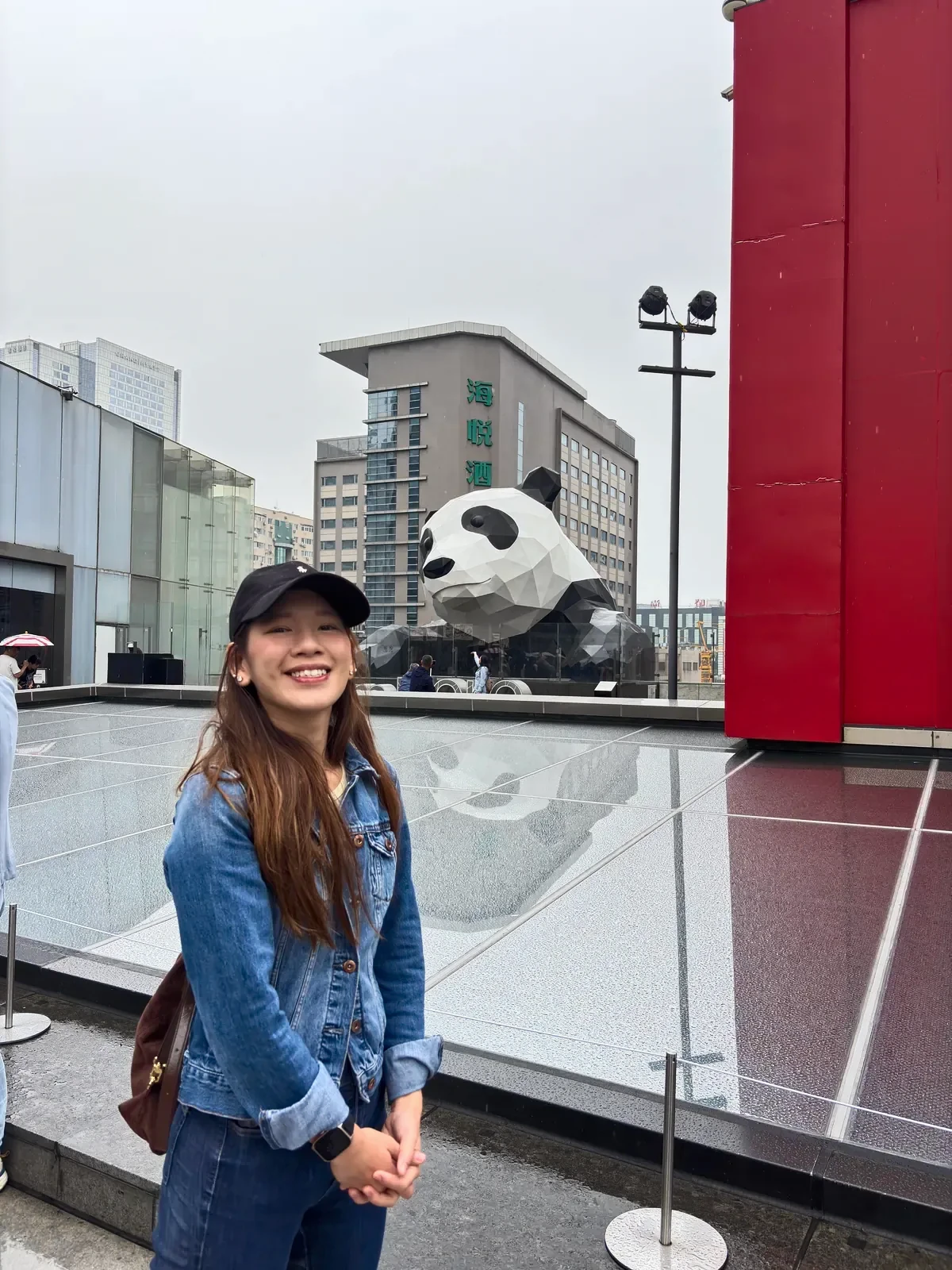 Woman on the Chengdu IFS roof terrace, with the giant faceted panda sculpture behind her