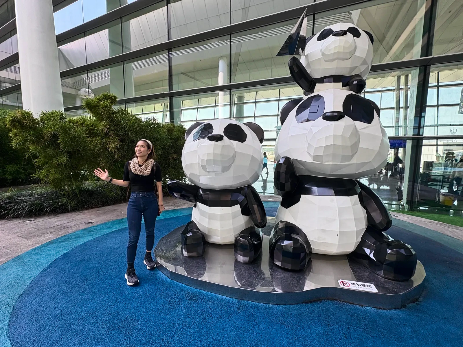 Woman beside three panda sculptures inside Tianfu Airport
