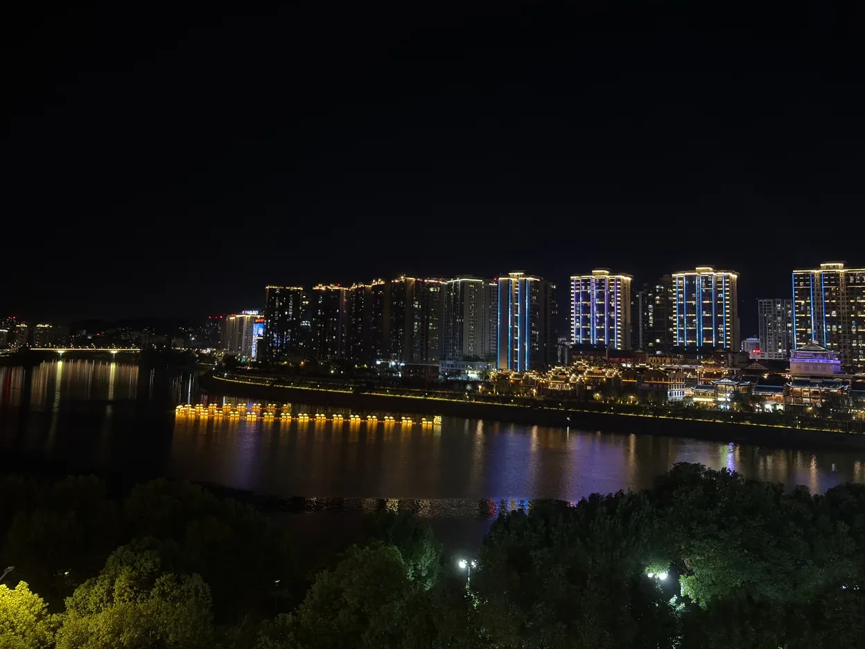 Zhangjiajie riverfront towers lit up at night across the water