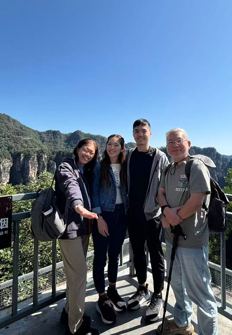 Family of four at a railing viewpoint above Zhangjiajie&rsquo;s sandstone pillars