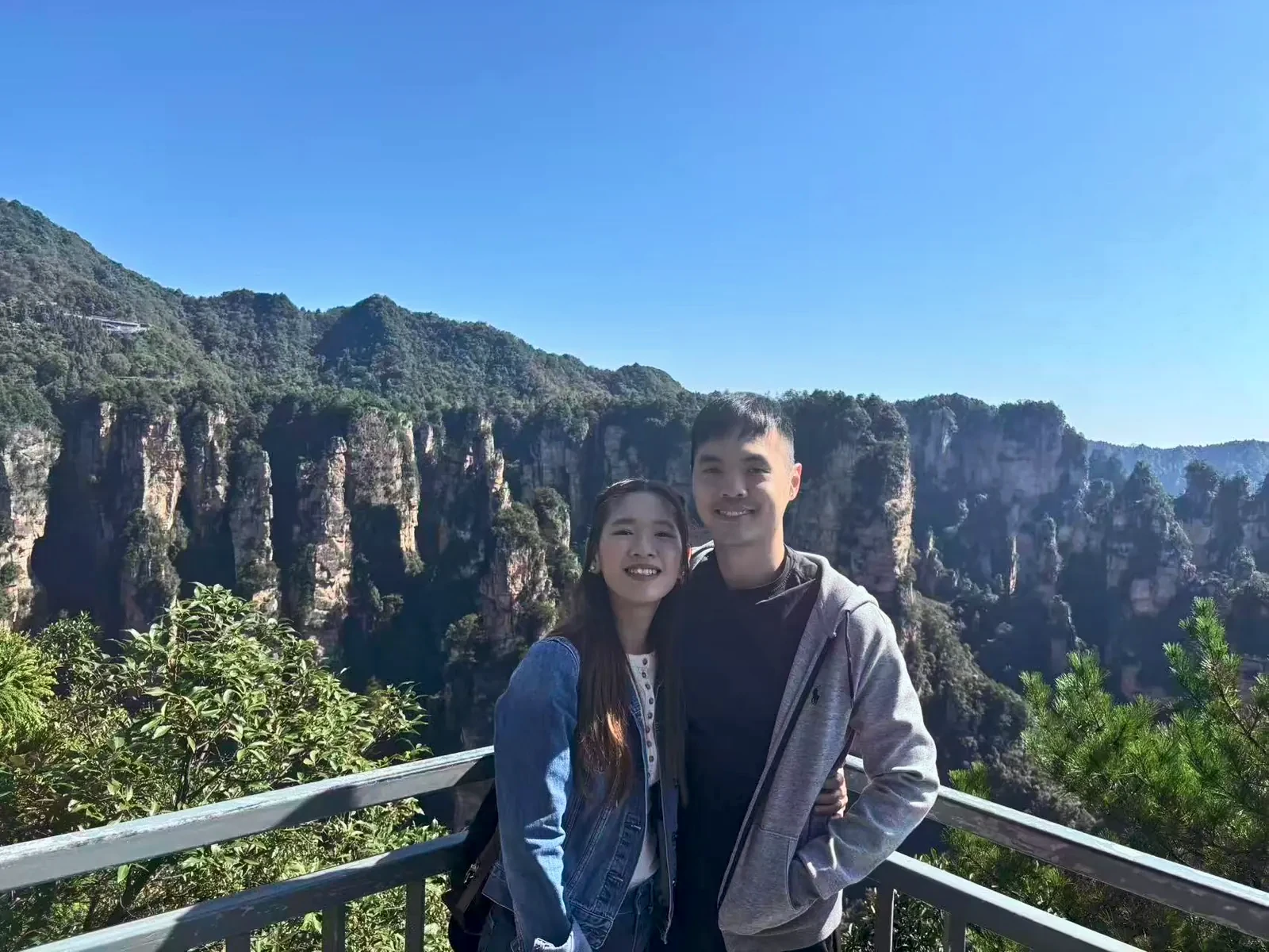 Couple at a railing above Yuanjiajie&rsquo;s sandstone pillars