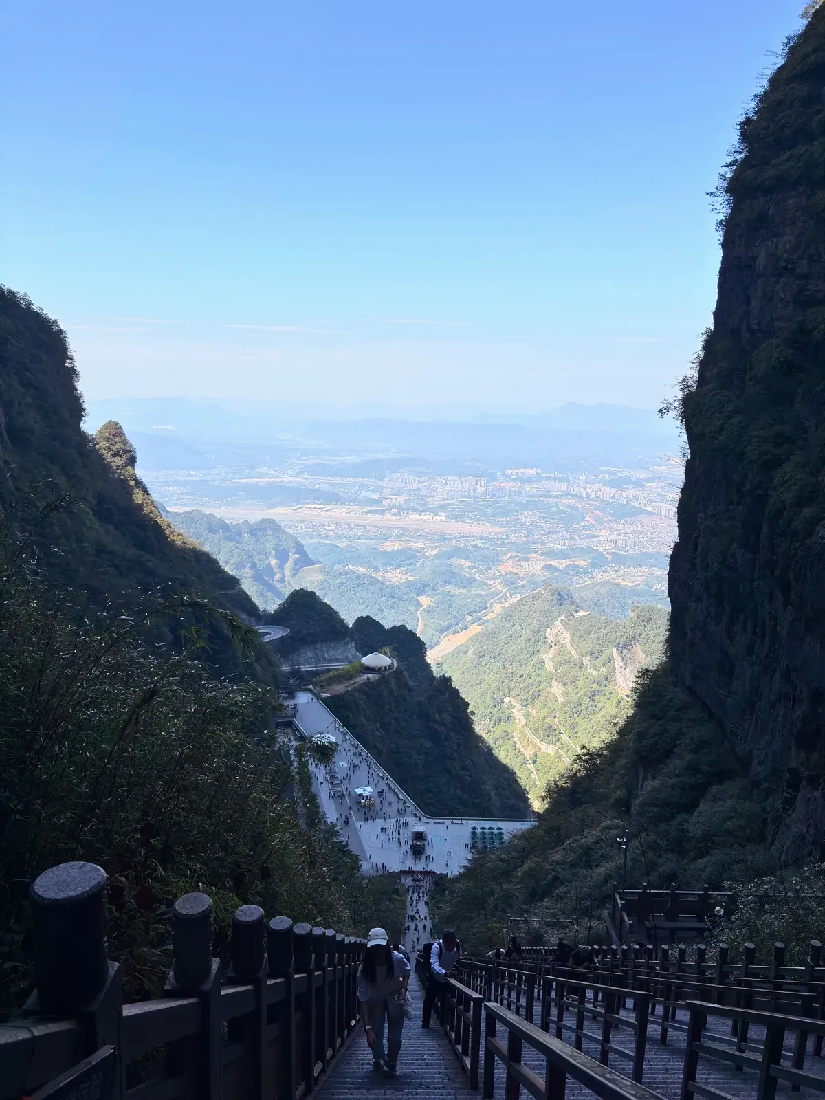Long stairway dropping between cliffs toward the city far below