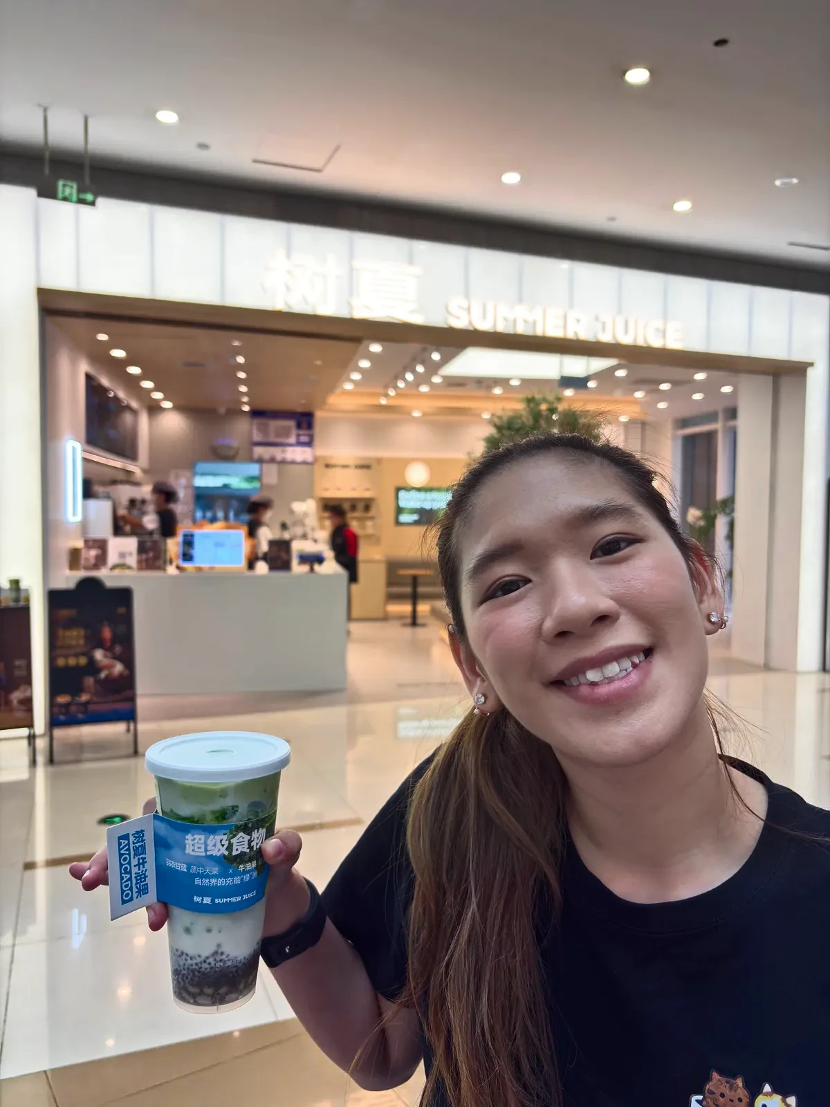 Woman holding a fruit drink with pearls during the layover